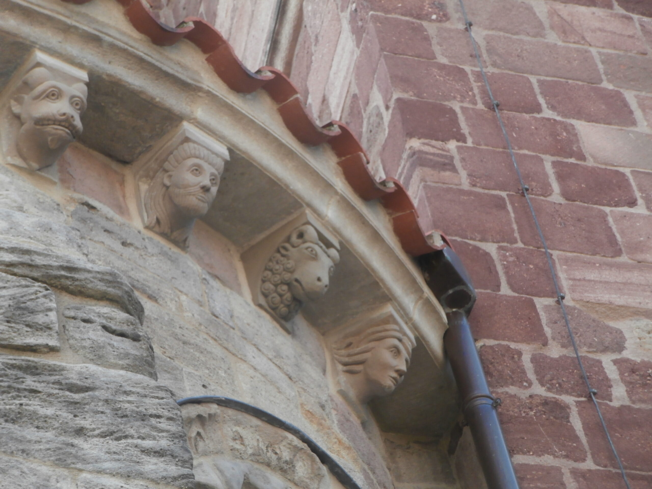 Têtes sculptées sur un mur.